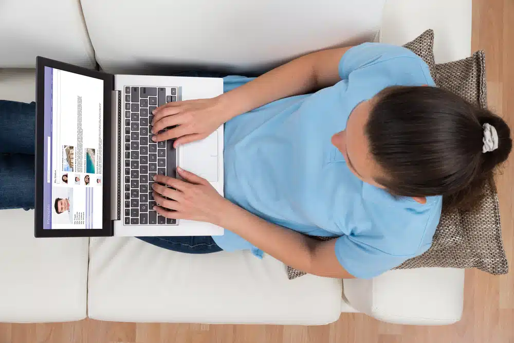 person typing on laptop, viewed from above