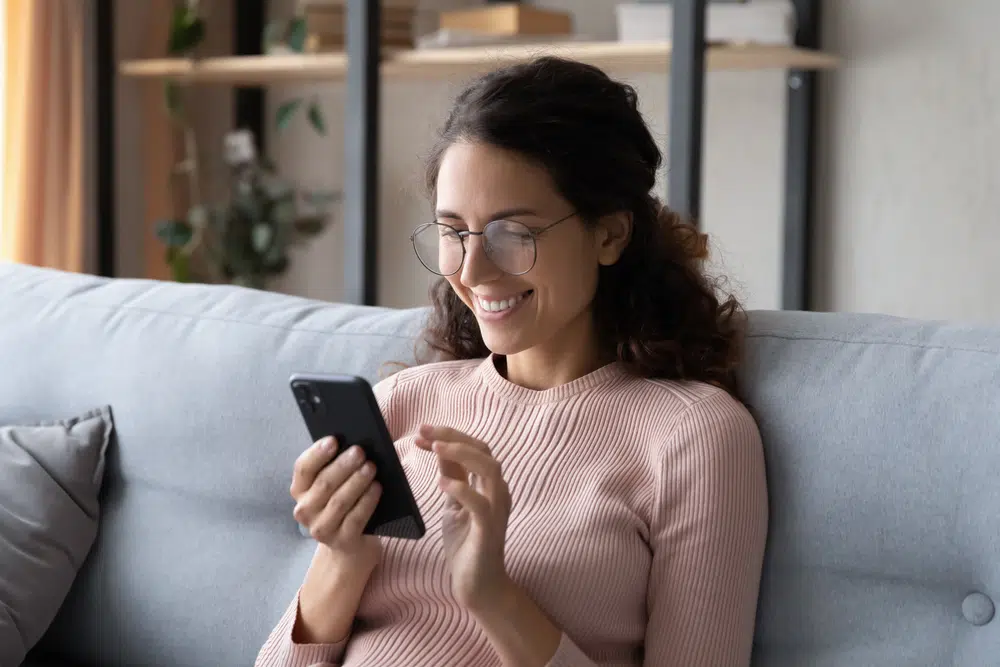 woman smiling using phone