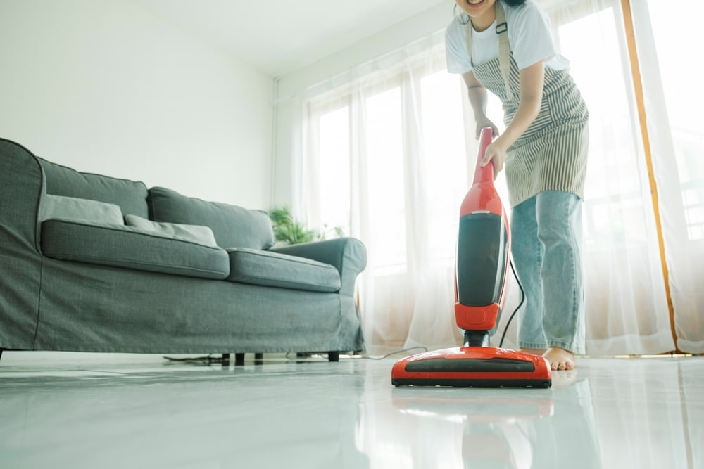 Person vacuuming a tiled floor